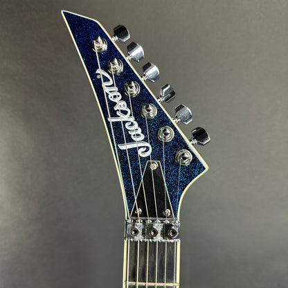 Front of headstock of Used Jackson LTD Wildwood Series Soloist Arch Top Extreme SL27 EX Blue Sparkle.