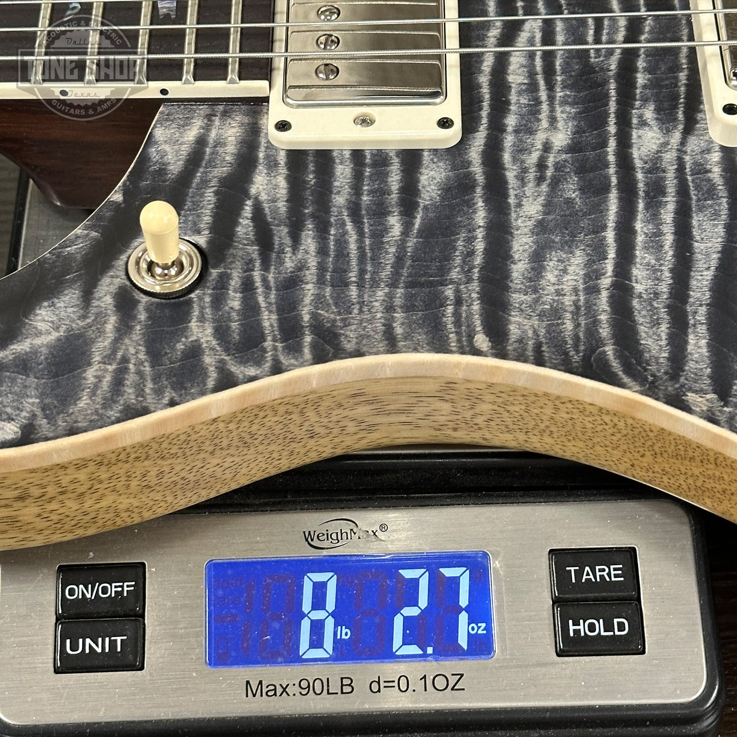 Guitar on a digital scale displaying weight