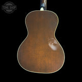 Back view of a wooden acoustic guitar with 'Tone Shop' logo.
