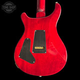 Back of Custom 24 Red electric guitar with a black pickguard on a black background, featuring 'Tone Shop' branding.