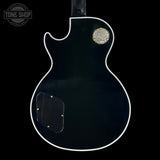Back view of a black electric guitar with Gibson logo, brand 'Tone Shop' visible.