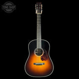 Acoustic guitar with a sunburst finish on a black background, featuring the Tone Shop logo.