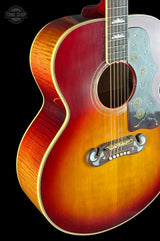 Close-up of a red acoustic guitar with a visible brand logo on a black background