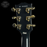 Gibson guitar headstock with tuning pegs on a black background