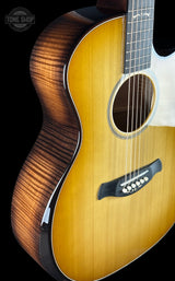 Close-up of a wooden acoustic guitar with a brand logo on a black background