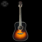 Acoustic guitar with a sunburst finish on a black background, featuring the Tone Shop logo.