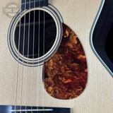 Close-up of an acoustic guitar's soundhole and strings on a textured surface with 'Tone Slick' branding.