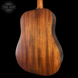 Back view of a wooden acoustic guitar with 'Tone Shop' branding.