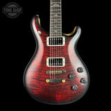 Red electric guitar with black background.