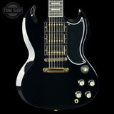 Black electric guitar with gold hardware on a black background, featuring the Tone Shop logo.