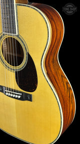 Acoustic guitar with a focus on the body and neck against a black background