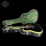 Acoustic guitar in a green case with 'Tone Shop' logo in the corner.