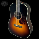 Acoustic guitar with a sunburst finish on a black background, featuring the Tone Shop logo.