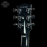Close-up of the headstock of a Gibson electric guitar, showing six chrome tuning pegs, model number CS 601403, and the Gibson logo on a black background.