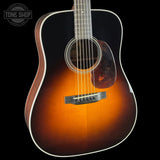 Acoustic guitar with a sunburst finish on a black background, featuring the Tone Shop logo.
