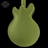 Green electric guitar body with 'Tone Shop' logo in the corner