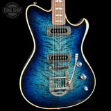 Blue electric guitar with a close-up view on a black background, featuring the Tone Shop logo.