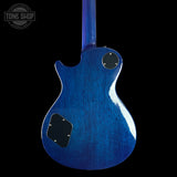 Blue electric guitar on a black background with 'Tone Shop' logo.