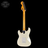 White electric guitar with a black pickguard on a white background, featuring the Tone Shop logo.