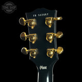 Gibson guitar headstock with gold tuning pegs on a black background