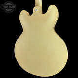 The back of an electric guitar with a smooth, matte cream finish, shown against a solid black background. A Tone Shop watermark is visible in the top-left corner.
