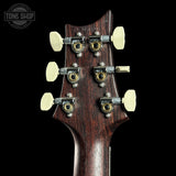 Close-up of a guitar headstock with tuning pegs on a black background, featuring the Tone Shop logo.