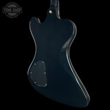 Glossy black electric guitar body on a black background with 'Tone Shop' logo.
