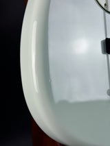 Close-up of a white wall clock with a blurred background