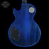 The back of a Gibson electric guitar with a glossy blue wood finish and a black pickguard, shown against a black background with a Tone Shop watermark in the top left.