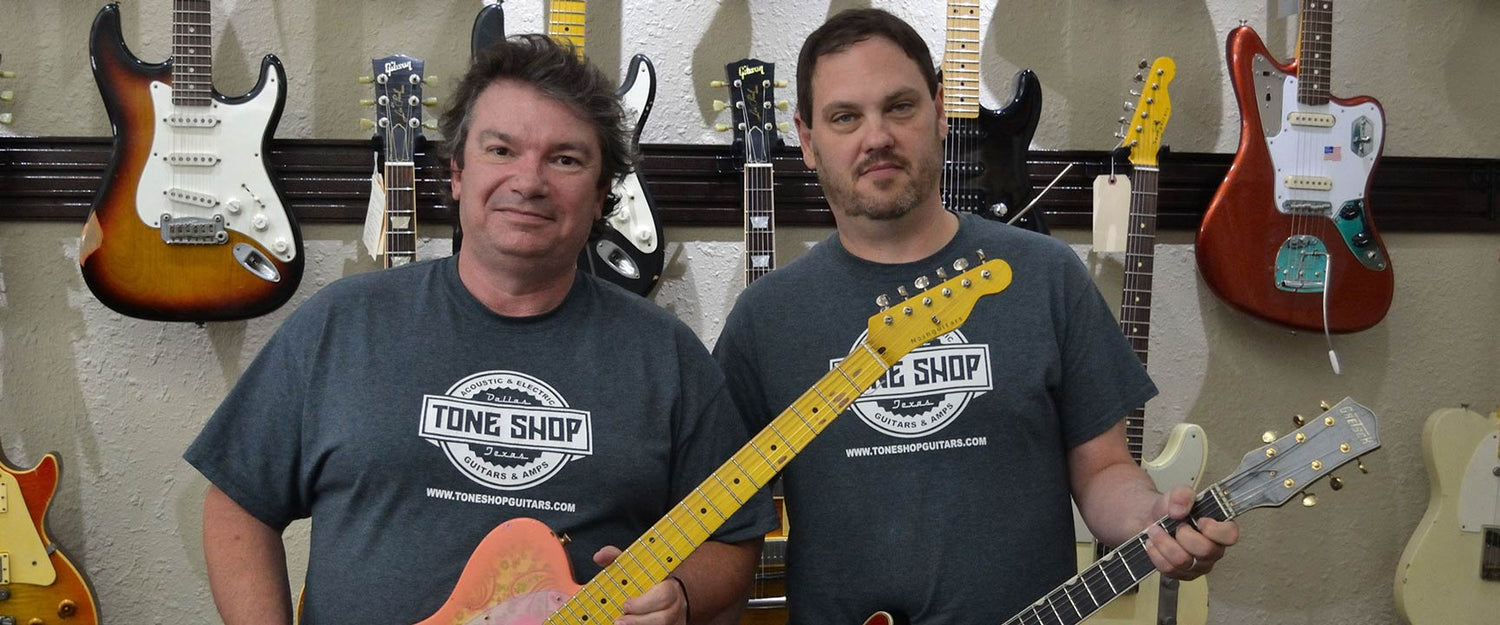 Tommy and Grant of Tone Shop Guitars, each holding an electric guitar.
