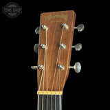 Close-up of a Martin guitar headstock with brand logo on a black background