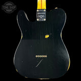 The back of a black Fender Telecaster electric guitar body, showing the glossy black finish with visible wear, scratches, and a small yellow paint mark. The gold-toned binding and hardware are visible along the edges and on the backplate.