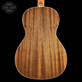 The back of a wooden acoustic guitar, showcasing a rich grain pattern in warm brown tones, set against a solid black background with a Tone Shop watermark in the top left corner.