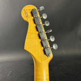 Guitar headstock with tuning pegs on a dark background
