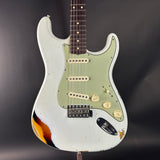 White electric guitar with a worn finish on a dark background