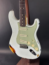 Close-up of a white electric guitar with a dark background