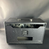 Black speaker cabinet with visible wear on a gray background