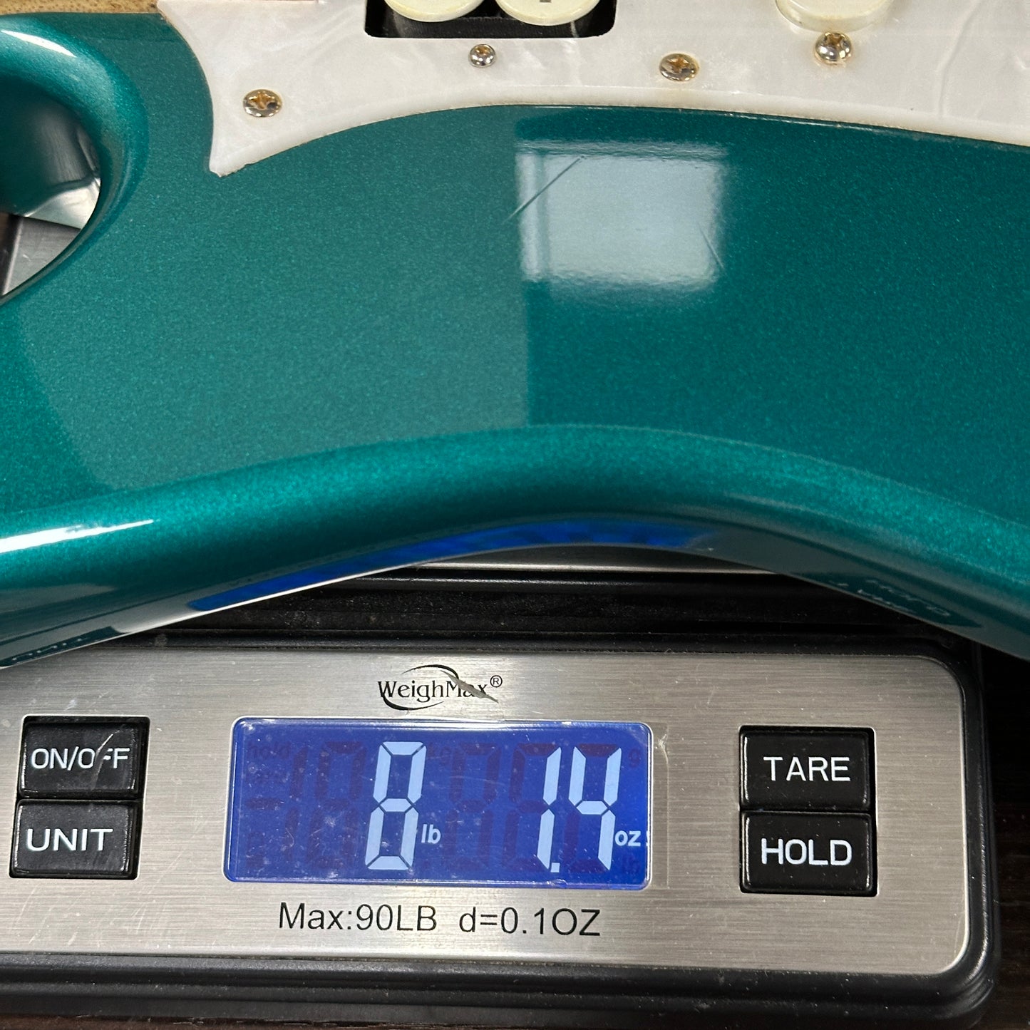 Teal digital scale with a digital display showing weight measurement