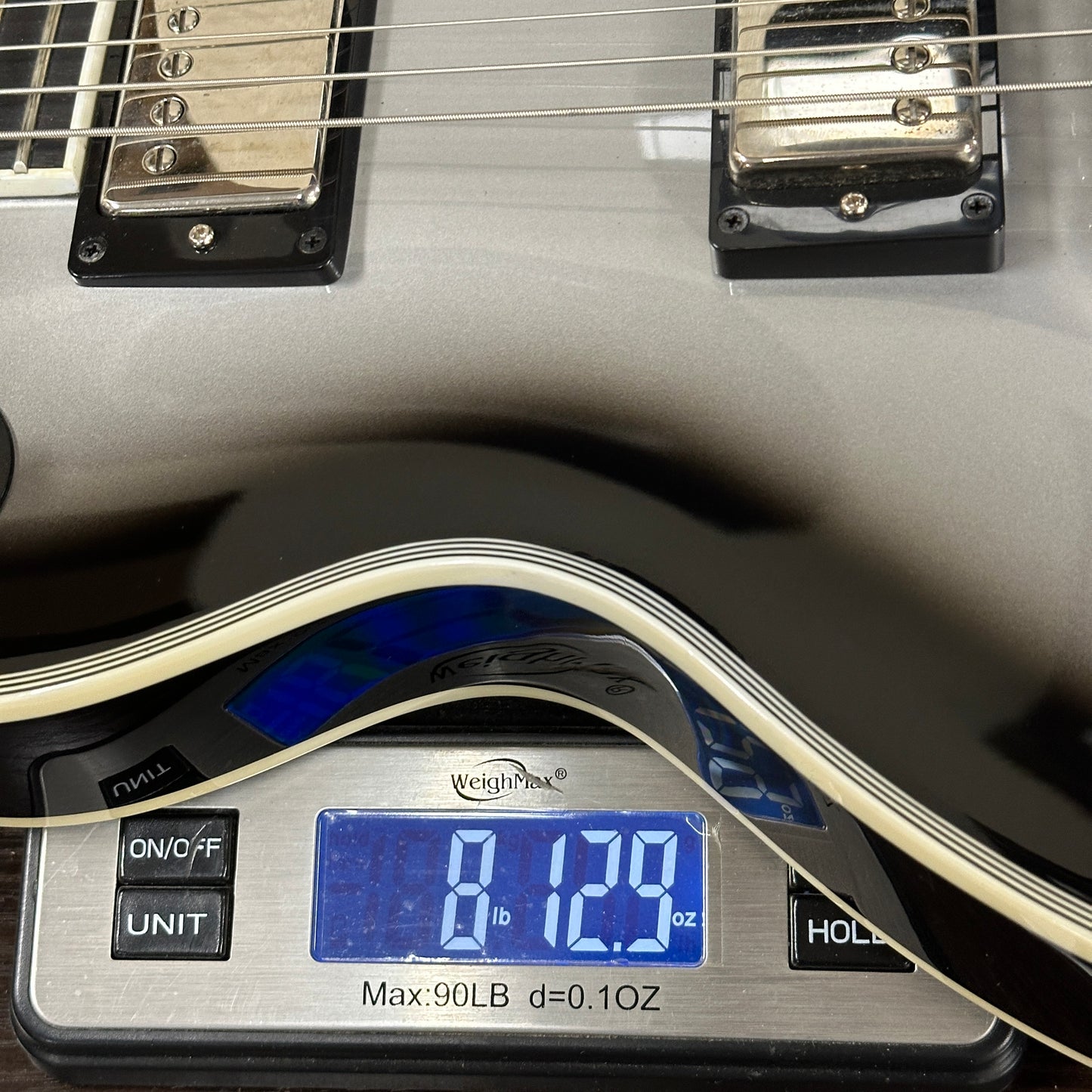 Guitar on a digital scale displaying weight