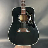 Black acoustic guitar with decorative elements on a gray background