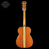The back of an acoustic guitar made of rich reddish-brown wood with a light natural wood center stripe, shown against a solid black background. A 'TONE SHOP' watermark is visible in the top-left corner.