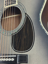 Close-up of an acoustic guitar's soundhole and strings on a gray surface