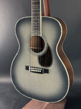 Acoustic guitar with a dark brown finish on a gray background