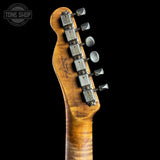 Close-up of the headstock of a Fender electric guitar, showing the six silver tuning pegs, brand logo engraving, and a warm figured maple wood finish against a solid black background.