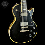 Front angle of Gibson Custom Limited 68 Les Paul Custom Ebony Top Gold Back Light Aged.