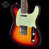 A classic electric guitar with a sunburst finish transitioning from dark red to orange, featuring a pale green pickguard and chrome hardware, shown against a black background with a Tone Shop watermark.