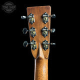 Close-up of the headstock of a Fender electric guitar, showing six black and gold tuners with the Fender logo, on a solid black background.