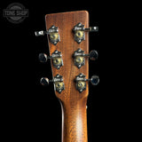 Close-up of the headstock of a Fazioli acoustic guitar, showing six tuning pegs with decorative Fazioli logos and gold-toned gears against a black background.