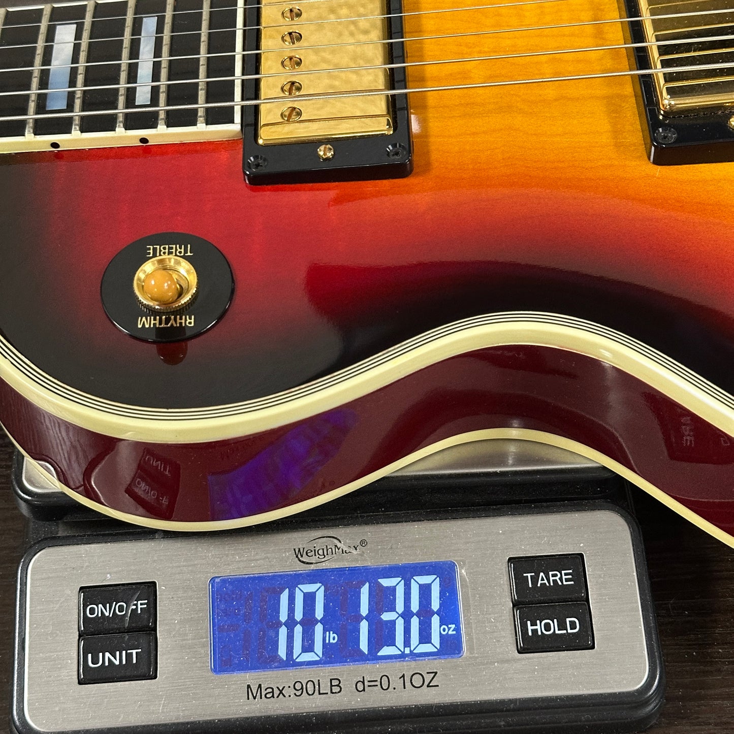Electric guitar on a digital scale displaying weight