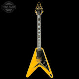Yellow electric guitar with a black background, featuring the 'Tone Shop' logo.